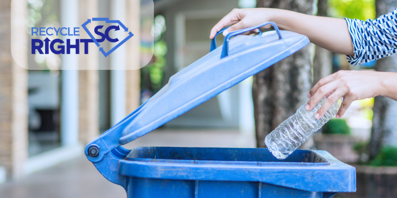 Person placing plastic bottle into a recycling bin image